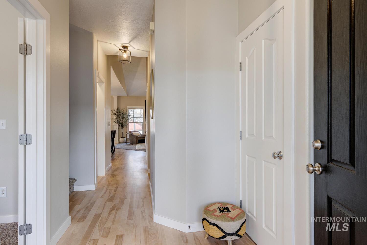 5572 West School Ridge Road Boise, ID 83714 - Photo 6 of 50 Corridor with baseboards and light wood finished floors