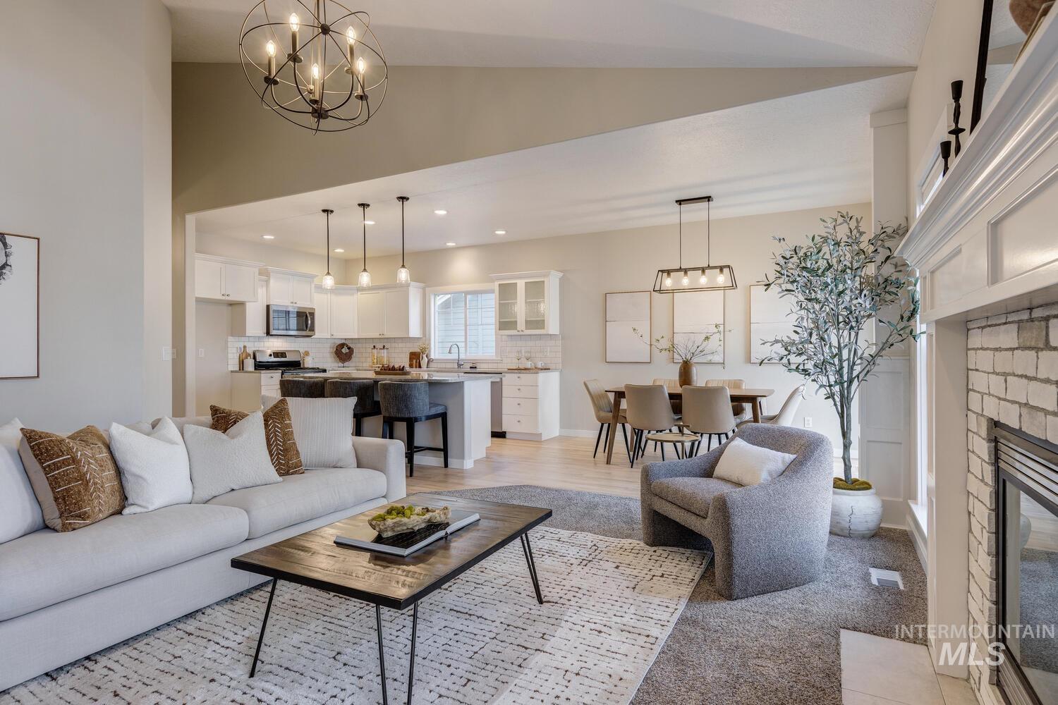 5572 West School Ridge Road Boise, ID 83714 - Photo 9 of 50 Living area featuring a chandelier, a glass covered fireplace, lofted ceiling, recessed lighting, and light wood-type flooring