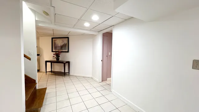 a view of a hallway with wooden floor and a cabinet