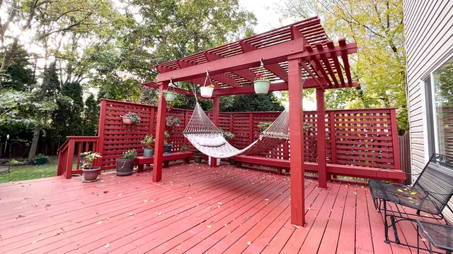 a view of deck with table and chairs a barbeque with wooden floor and fence
