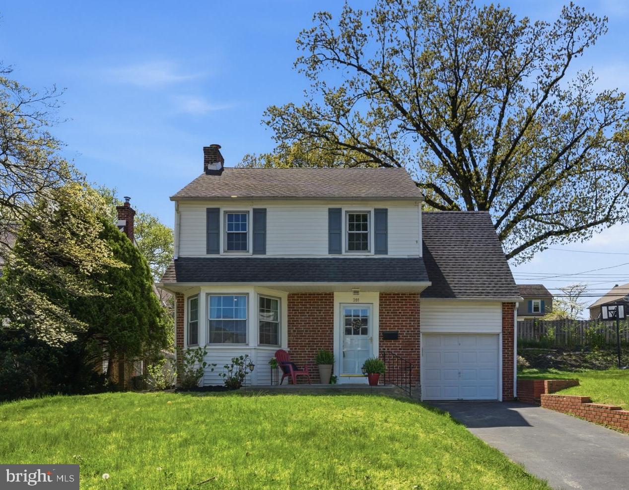 a front view of a house with a yard and trees