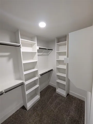 a view of walk in closet with empty racks