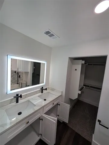 a bathroom with a double vanity sink and mirror