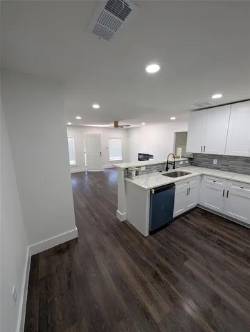 a view of a kitchen with a sink and wooden floor