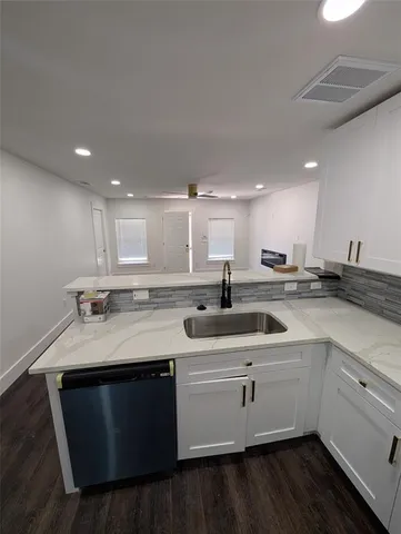 a view of kitchen with refrigerator sink and wooden cabinets