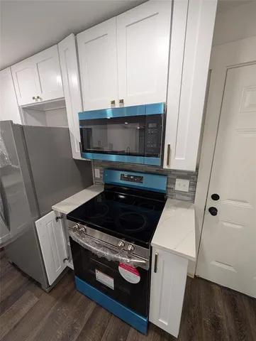 a kitchen with stainless steel appliances granite countertop a sink a stove and a refrigerator