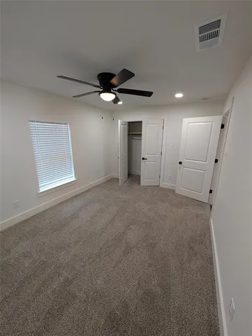 an empty room with a ceiling fan and a window