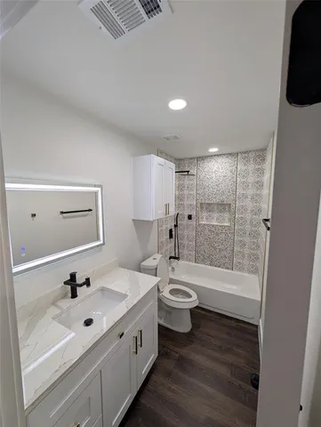 a bathroom with a bathtub shower sink and toilet