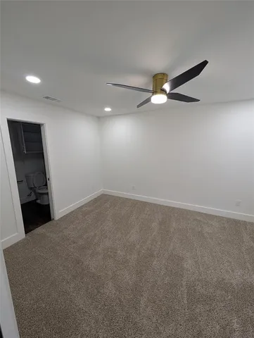 an empty room with closet and a chandelier fan