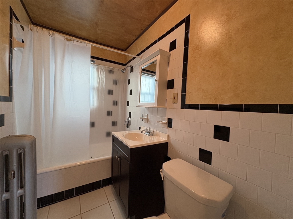 155-157 Hillside Street, Unit 2 Boston, MA 02120 - Photo 15 of 15 a bathroom with a sink a toilet and shower curtain