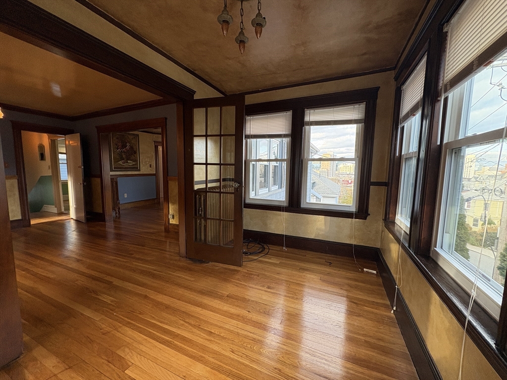 155-157 Hillside Street, Unit 2 Boston, MA 02120 - Photo 4 of 15 a view of empty room with wooden floor and fan