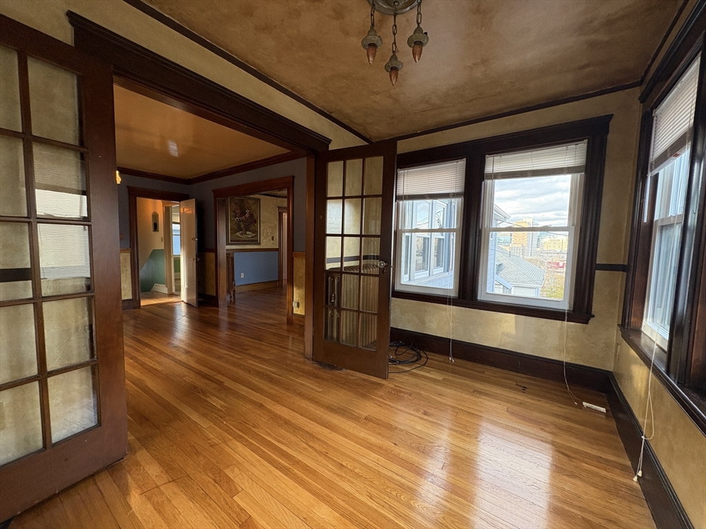 155-157 Hillside Street, Unit 2 Boston, MA 02120 - Photo 5 of 15 a view of empty room with wooden floor and fan