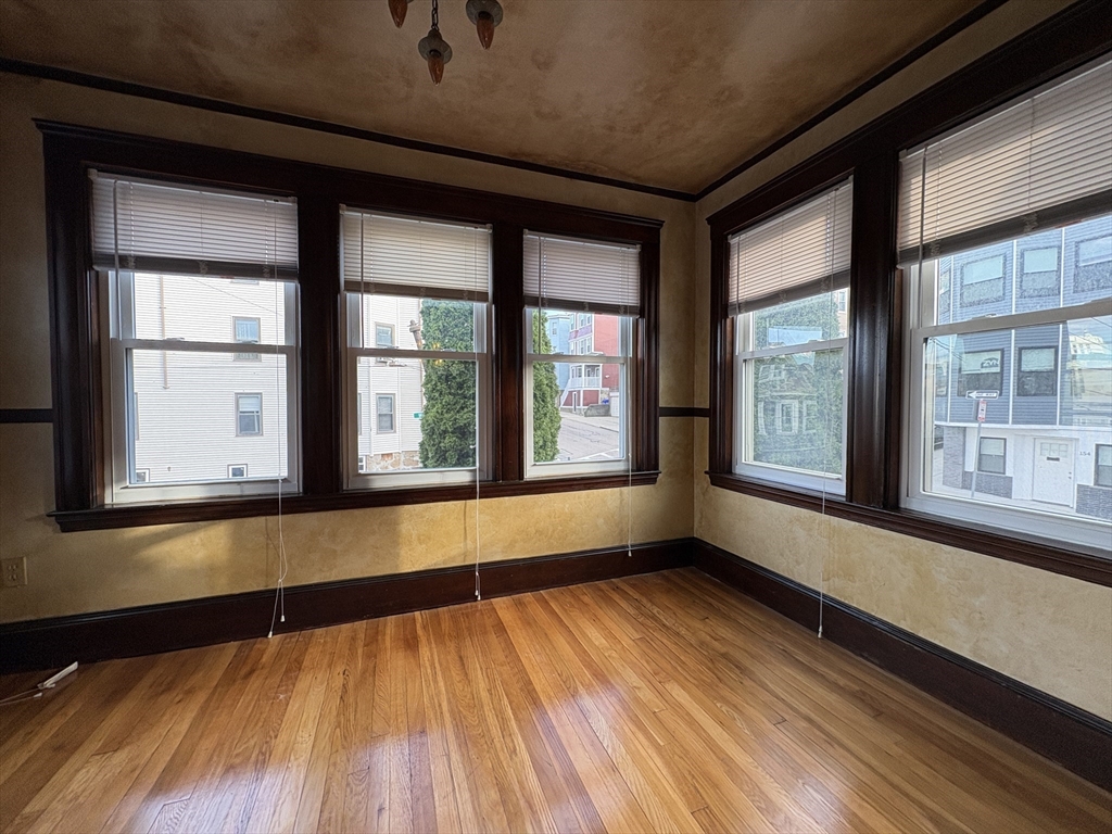 155-157 Hillside Street, Unit 2 Boston, MA 02120 - Photo 6 of 15 a view of an empty room with wooden floor and a window