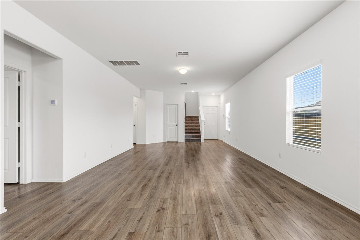 101 Rowdy Yates Way Jarrell, TX 76537 - Photo 6 of 32 Spacious interior featuring wood-finish flooring, white walls, and a staircase with wood treads