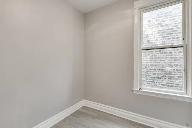 a view of a small space with wooden floor and a window
