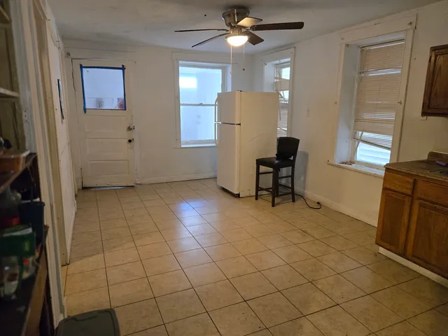 a view of a kitchen with furniture and a refrigerator