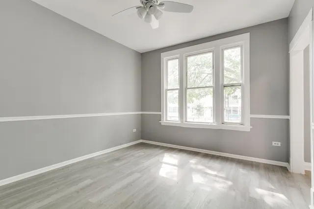 an empty room with a window and a ceiling fan