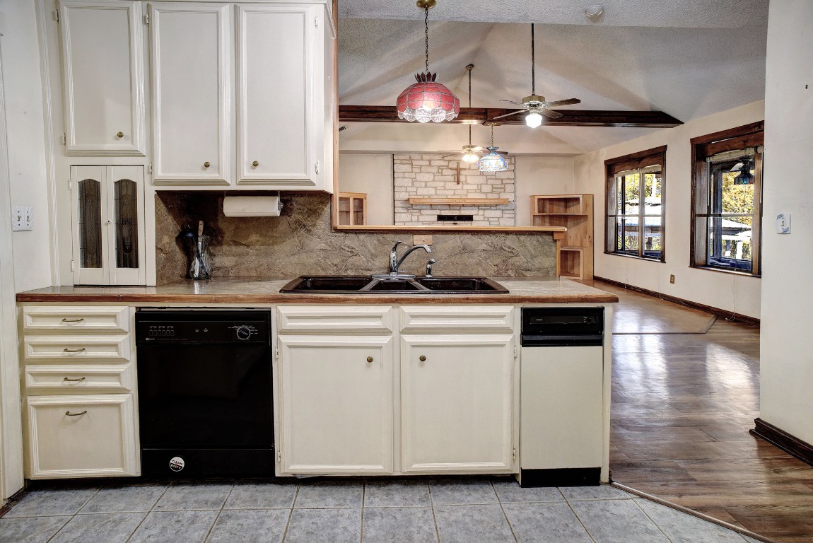 113 My Road Bastrop, TX 78602 - Photo 35 of 35 Kitchen featuring dishwasher, backsplash, hanging light fixtures, open floor plan, and light countertops
