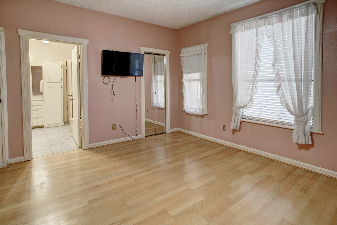 113 My Road Bastrop, TX 78602 - Photo 23 of 35 Unfurnished bedroom with light wood-style floors, ensuite bathroom, and a closet