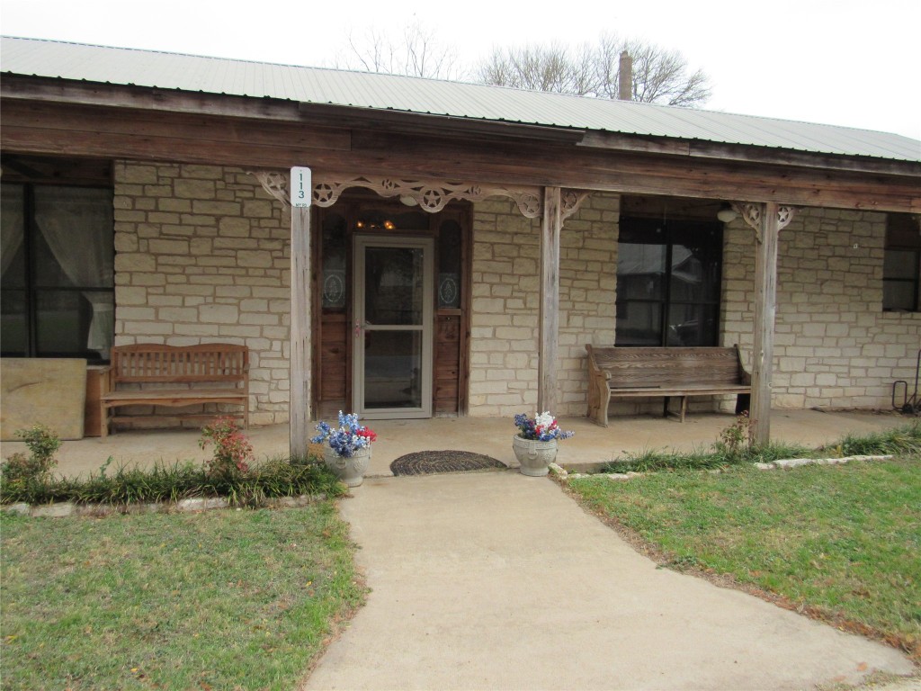 113 My Road Bastrop, TX 78602 - Photo 3 of 35 Entrance to property featuring stone siding, a porch, and a yard