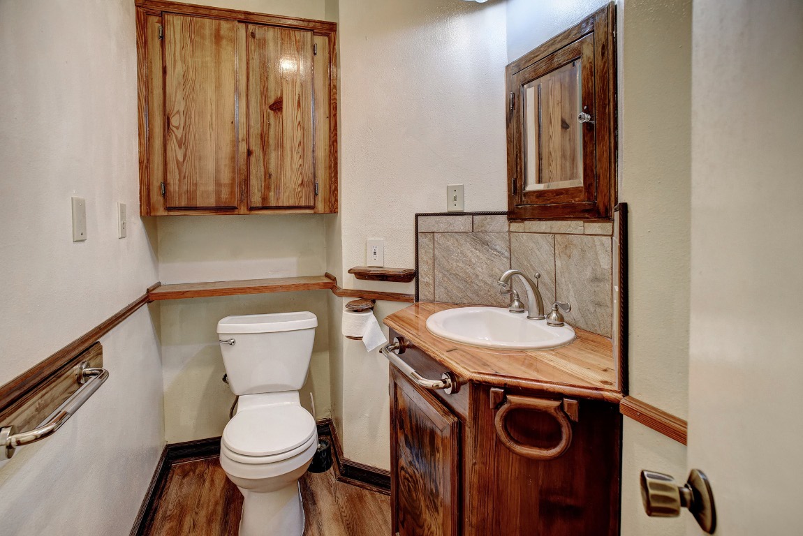 113 My Road Bastrop, TX 78602 - Photo 30 of 35 Half bath featuring vanity, light wood-type flooring, and backsplash