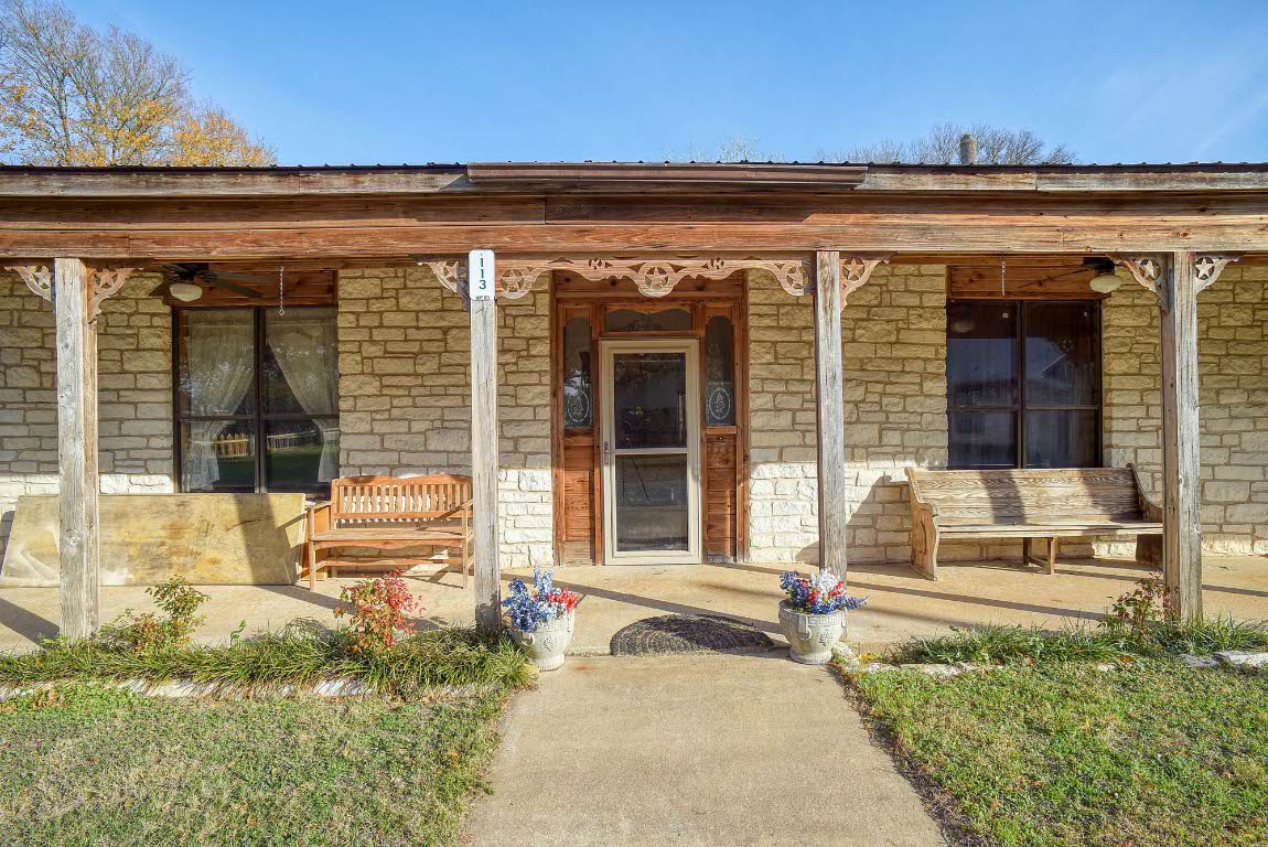 113 My Road Bastrop, TX 78602 - Photo 9 of 35 Entrance to property with stone siding, covered porch, and ceiling fan