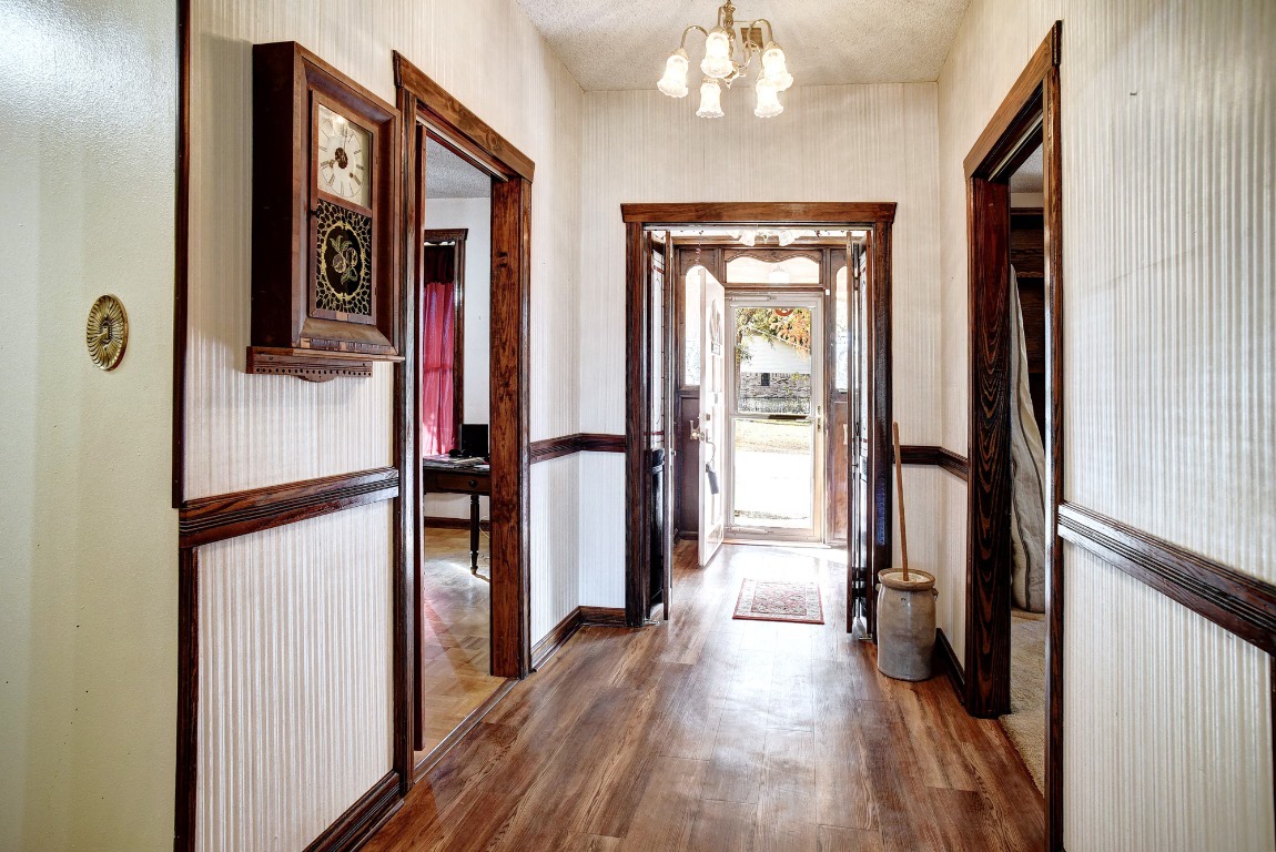 113 My Road Bastrop, TX 78602 - Photo 10 of 35 Hallway featuring wood-type flooring and a chandelier
