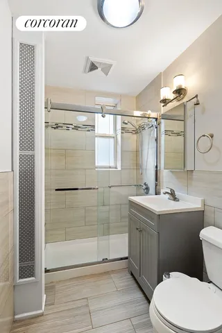 an empty room with wooden floor cabinet and windows
