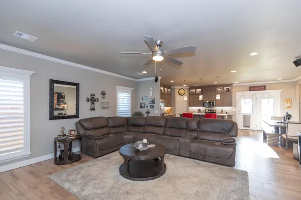 a living room with furniture a table and wooden floor