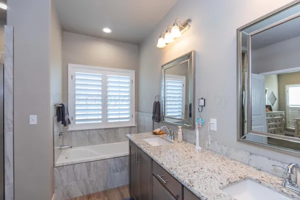 a en suite bathroom with a granite countertop sink and a mirror
