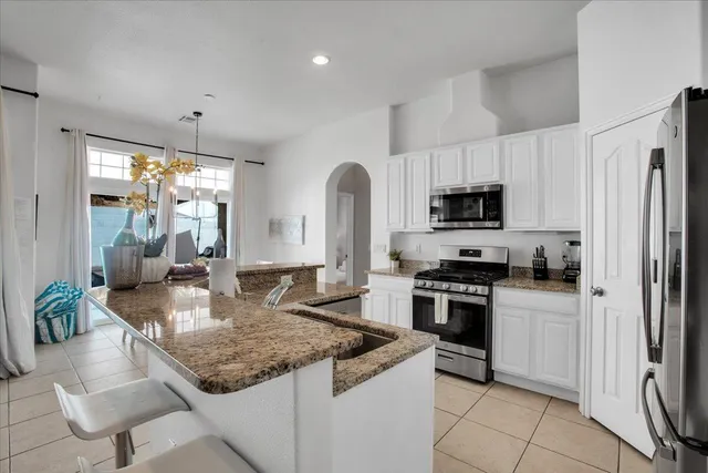 a bedroom with a large bed and a chandelier