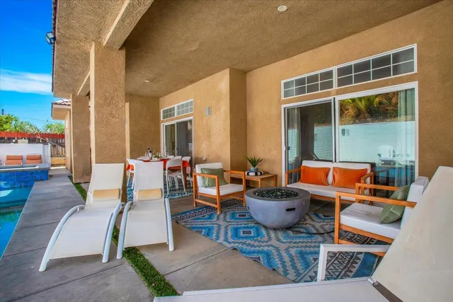 a blue swimming pool with outdoor seating and yard