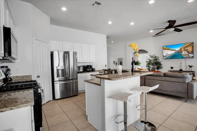 a kitchen with stainless steel appliances granite countertop a dining table and chairs