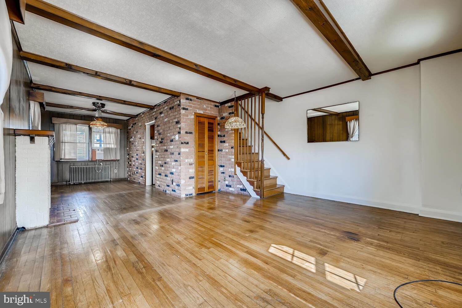 318 Arden Road West Baltimore, MD 21225 - Photo 6 of 32 a view of an empty room with wooden floor and stairs