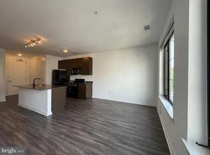 a view of kitchen with wooden floor and electronic appliances
