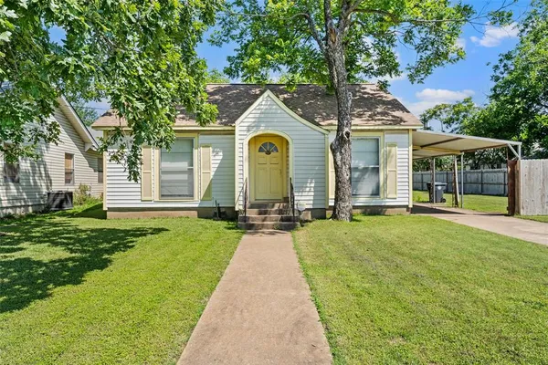 a front view of a house with yard and green space