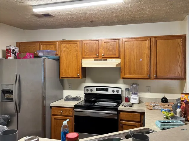 a kitchen with a refrigerator and a stove