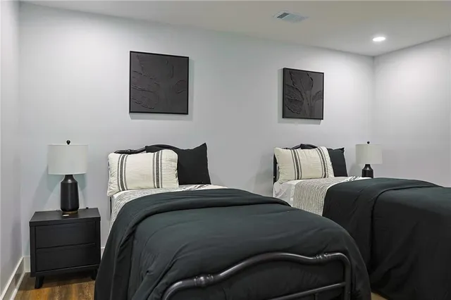 a bedroom with a bed and a lamp on dresser