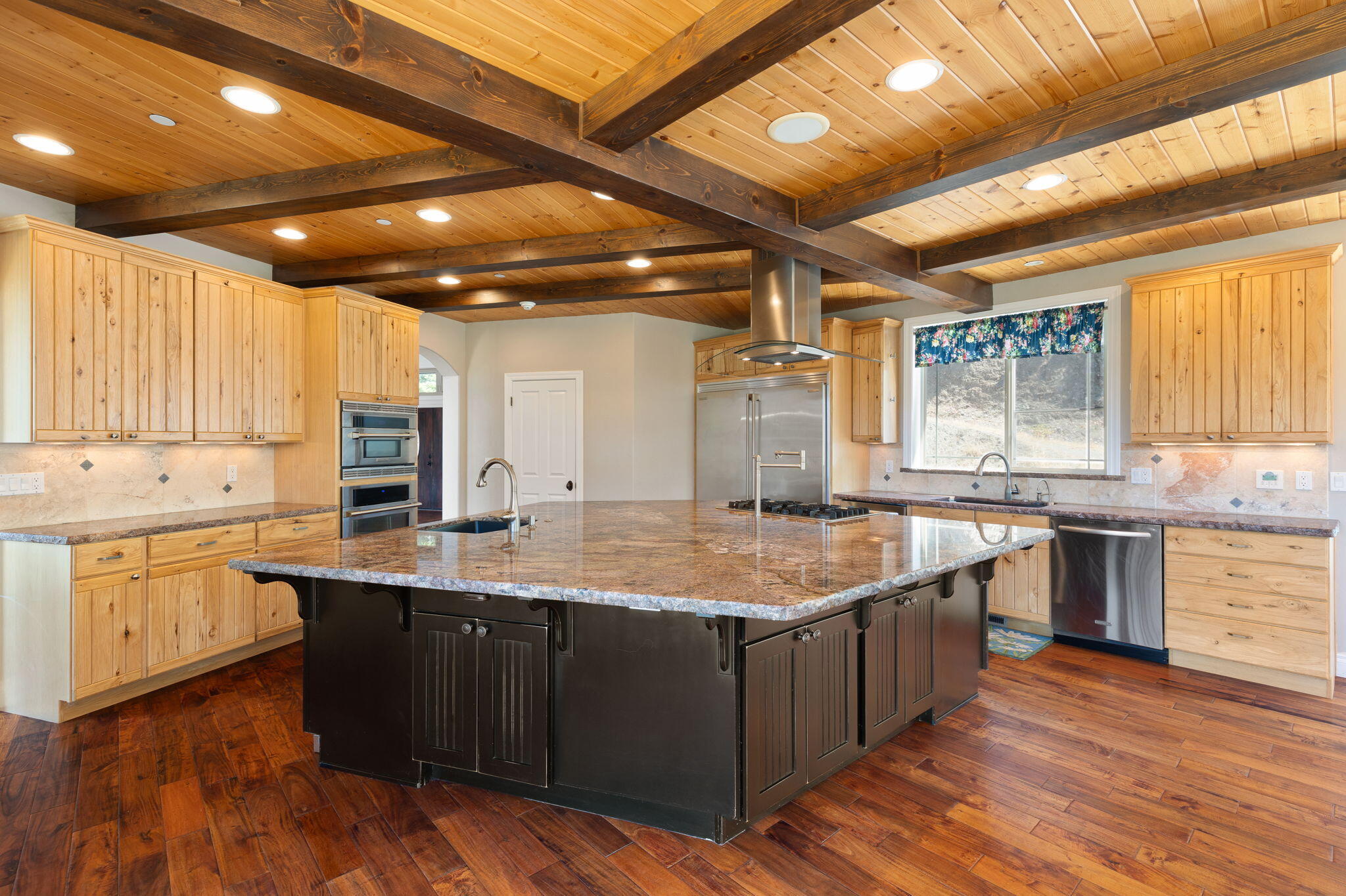 7304 North Applegate Road Grants Pass, OR 97527 - Photo 5 of 87 a large kitchen with kitchen island granite countertop a sink and dishwasher stove with wooden floor