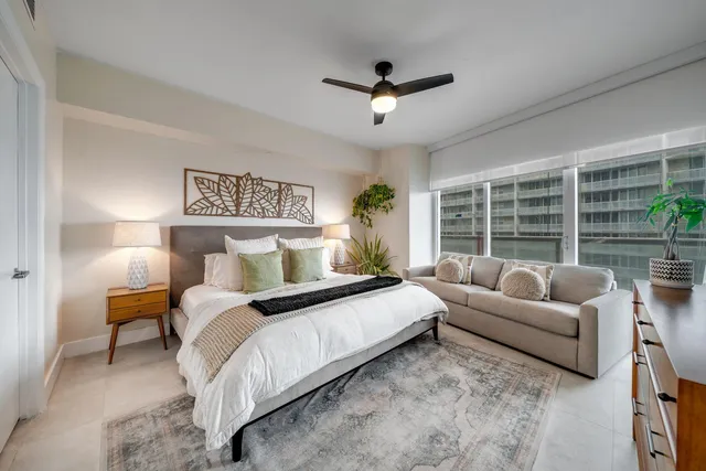 a bedroom with furniture and a large window