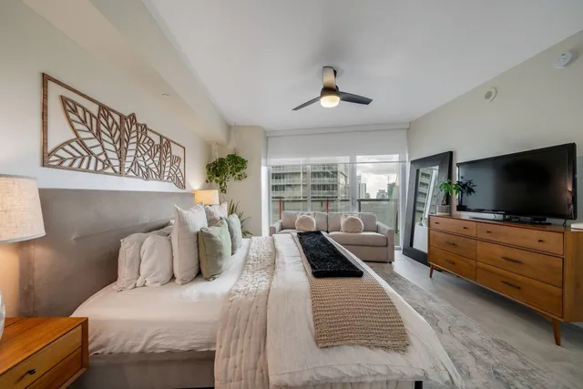 a bedroom with a large bed and a flat screen tv