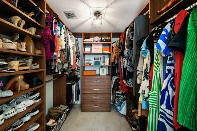 a view of walk in closet with clothes and shoes