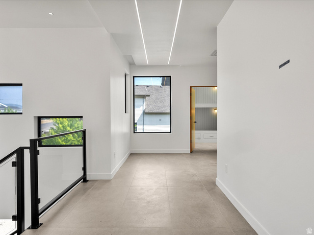 2610 Foxridge Road Garden City, UT 84028 - Photo 43 of 71 Recessed linear lighting, tile flooring, black frame windows, and a glass panel railing