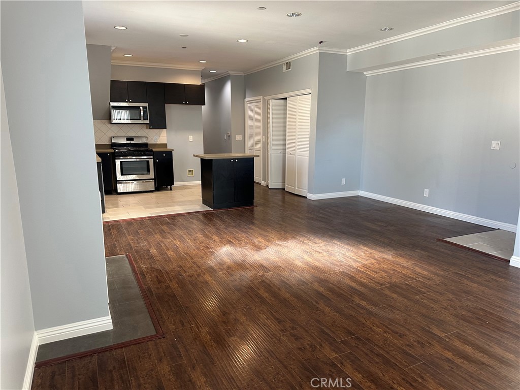 14343 Tiara Street, Unit 2 Sherman Oaks, CA 91401 - Photo 9 of 23 an empty room with wooden floor and stainless steel appliances