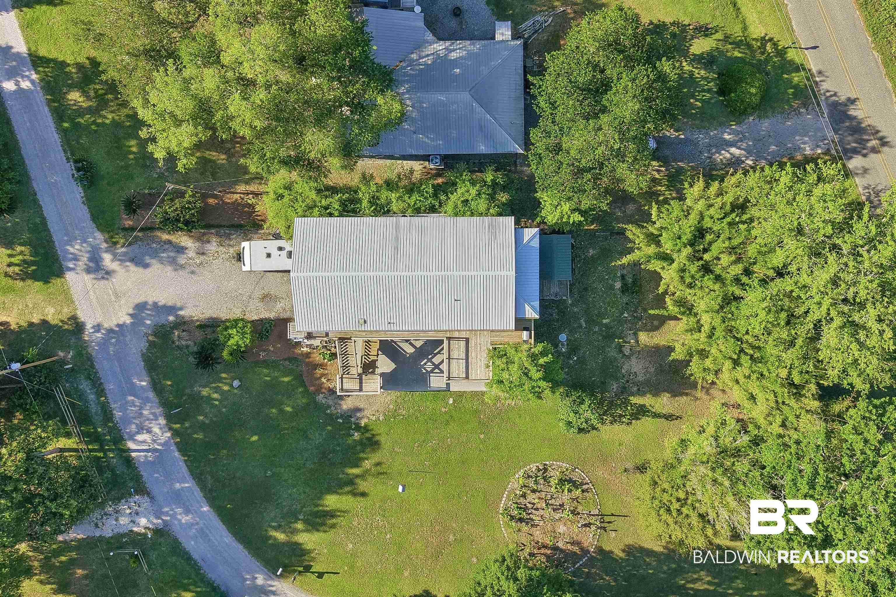 9624 North Bay Street Foley, AL 36535 - Photo 53 of 59 Aerial property overview showcasing a metal roof structure, extensive gravel driveway, and surrounding mature trees
