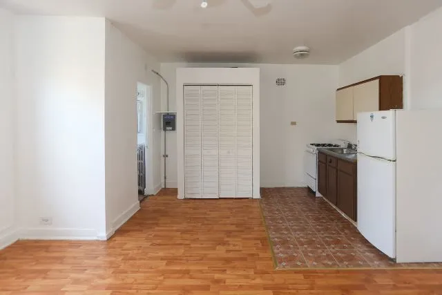 a view of a kitchen with a sink and a refrigerator