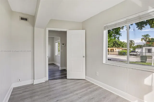 wooden floor in an empty room with a window