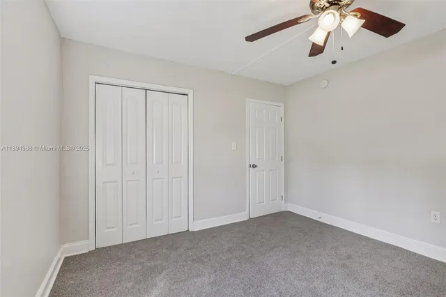 a view of an empty room and chandelier fan