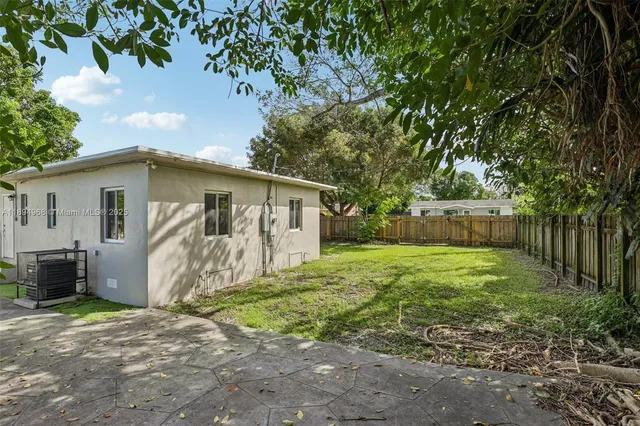 a view of a house with backyard and a tree