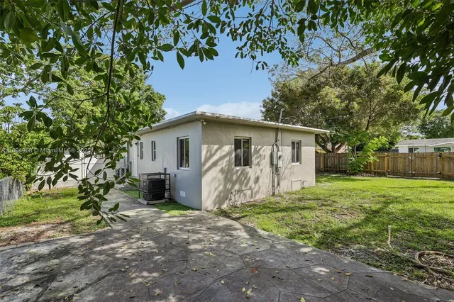 a view of a house with backyard and a tree